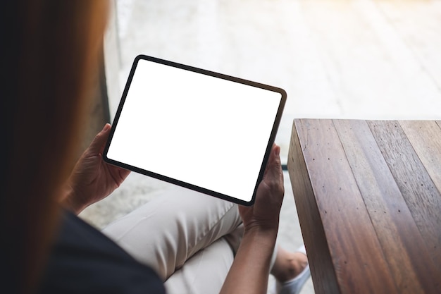 Mockup-afbeelding van een vrouw met een digitale tablet met een leeg wit bureaubladscherm