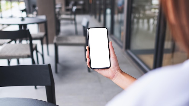 Mockup-afbeelding van een vrouw met een mobiele telefoon met een leeg wit bureaubladscherm