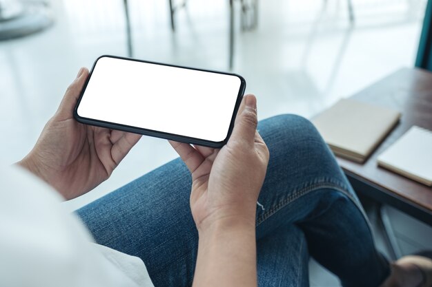 Mockup-afbeelding van een vrouw met een zwarte mobiele telefoon met een leeg bureaublad horizontaal