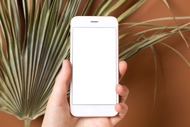 Mockup afbeelding van hand met mobiele telefoon met leeg wit scherm.