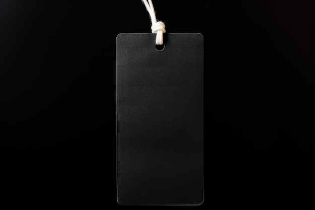 Mockup of a black empty tag with a rope on a black background Place for text