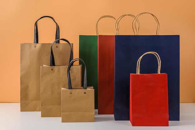 Mockup di pacchetto artigianale vuoto o shopping bag di carta colorata con manici