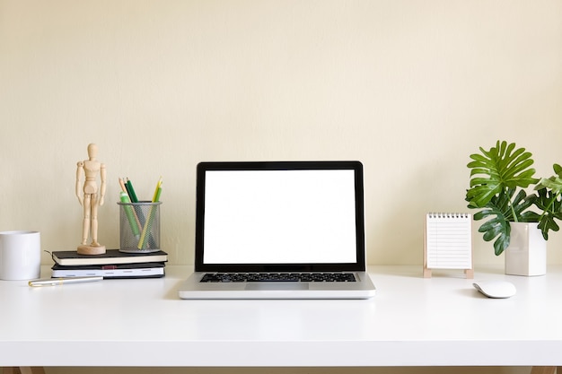 Mockup blank screen computer laptop on desk. Workspace with laptop and office supplies.