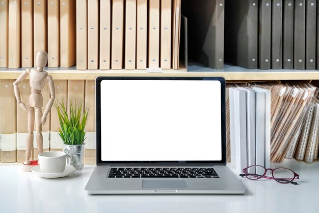 Mockup blank screen laptop with copy space and office supplies on white desk