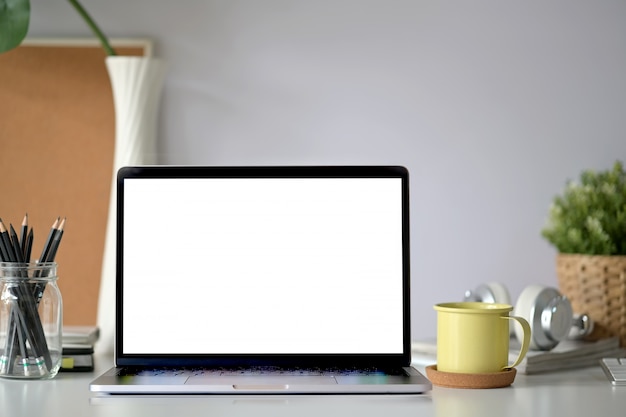 Photo mockup blank screen laptop on wood workspace table