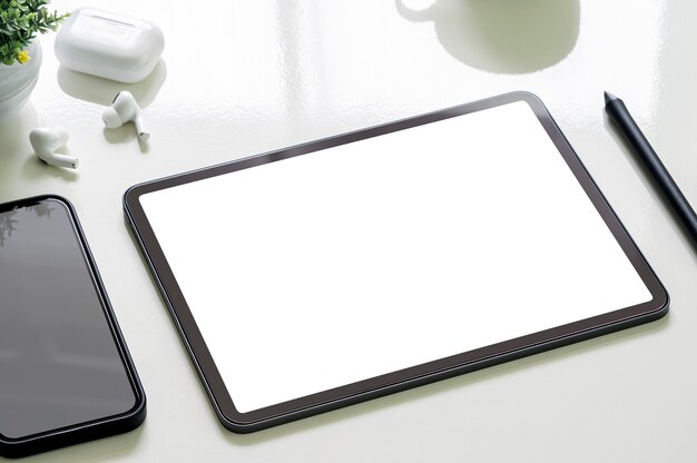Photo mockup blank screen portable tablet and smartphone on white top table.