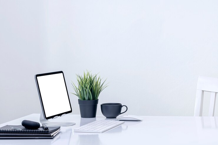 Photo mockup blank screen tablet on stand holder with keyboard on white table in white room.