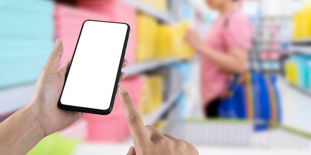 Mockup blank white screen mobile phone with finger point and
touch on touchsreen with women are shopping in department
stores