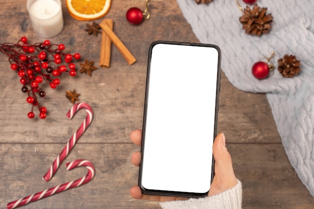 Photo mockup cell phone on background wooden table during the christmas holidays.