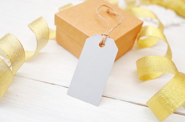 Mockup christmas gift with blank tag on white wooden background