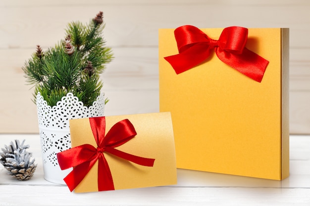 モックアップクリスマスパッケージと赤の弓が付いている手紙
