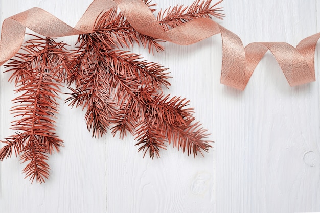 Foto filiale dell'albero di natale del modello e nastro del regalo dell'oro, flatlay su bianco