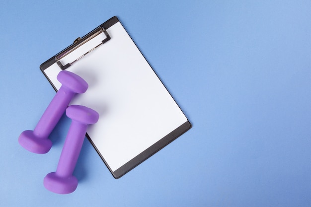 Mockup clipboard with Gym equipment dumbbell on blue