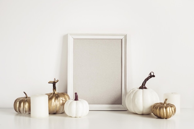 Mockup composition with photo frame white pumpkins and candles Copy space for artwork