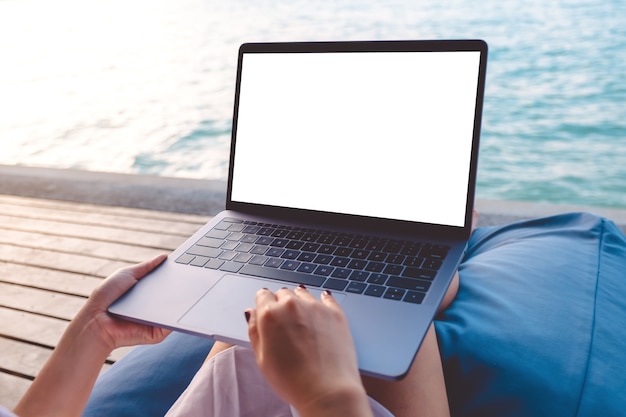 Mockup computer laptop with people hands by the sea