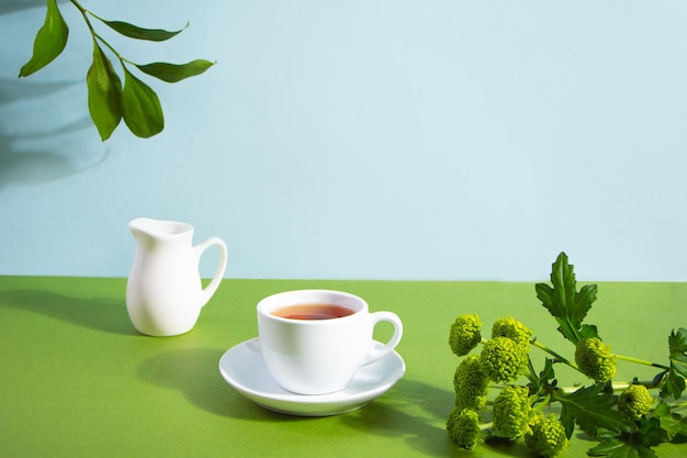 Mockup tazza di tè pianta di ramo foglia verde sullo sfondo spazio libero per il testo