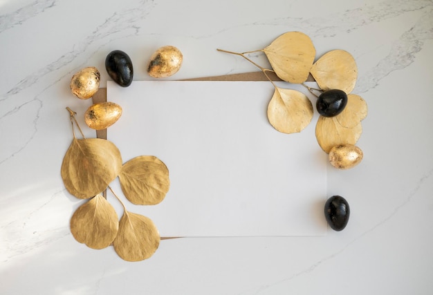 Mockup, Easter golden and black eggs with golden eucalyptus leaves.