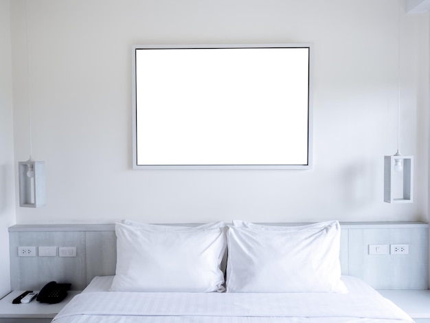 목업 빈 흰색 가로 직사각형 그림 사진 또는 아트 프레임이 매달려 램프가 있는 침대 머리 위에 흰 벽 배경에 매달려 있습니다. 목업 포스터 그림 템플릿 사진 프레임
