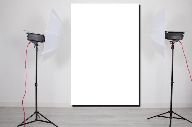 Mockup empty room with blank white screen poster studio lights on tripod stands in Concept background with modern lighting equipment for professional photographer