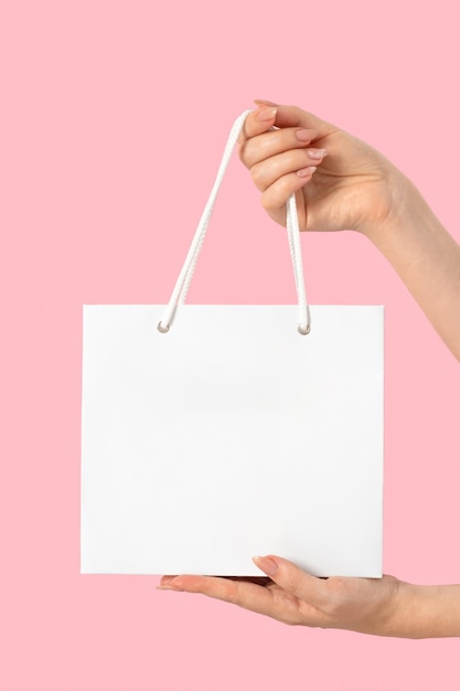Фото Макет женские руки держат белую бумажную стильную сумку пустой шаблон для вашего дизайна и логотипа