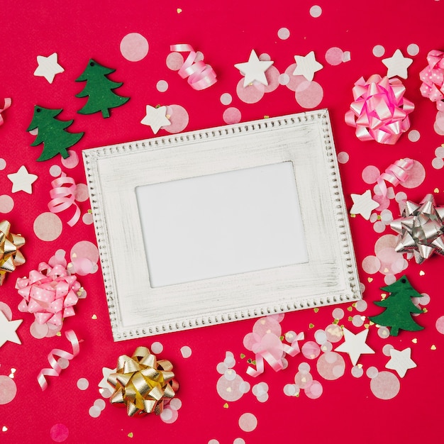 Mockup frame with  confetti and decorations. Holiday composition for New year or Christmas celebration. Flat lay, top view