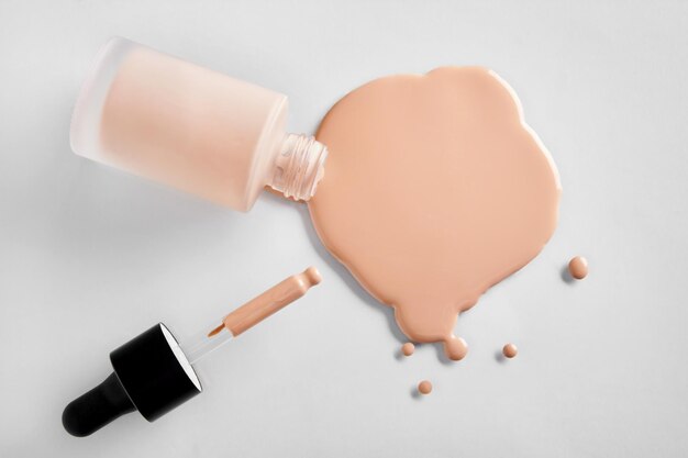 Mockup glass bottle of correction cosmetic product with pipette Spilled Liquid foundation Beauty branding concept