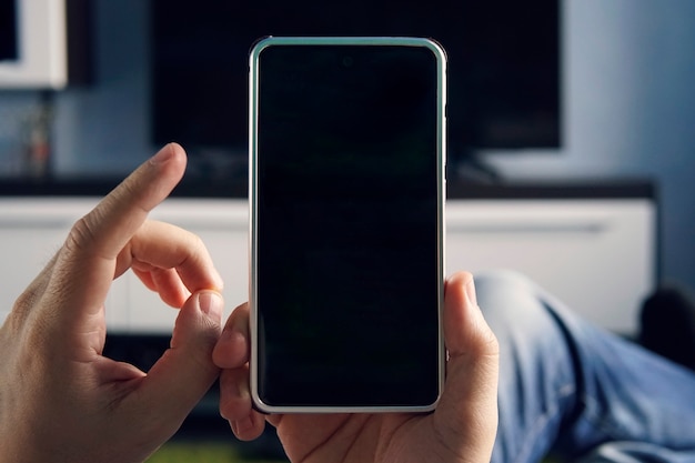 Mockup image blank white screen cell phone.men hand holding texting using mobile at home. background empty space for advertise text. contact business, technology device, people communication,