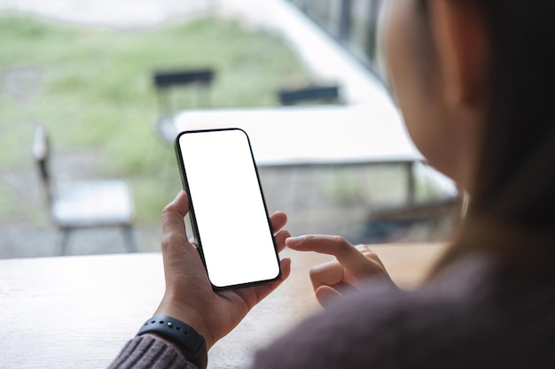 Mockup image of closeup woman hand holding mobile phone with blank white smartphone screen at the outdoor