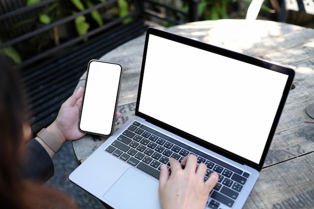 Foto computer di immagine mockup, schermo vuoto del telefono cellulare per la digitazione a mano del testo, utilizzo di laptop contact business ricerca di informazioni sul posto di lavoro sulla scrivania in ufficio design spazio di lavoro creativo sulla scrivania in legno