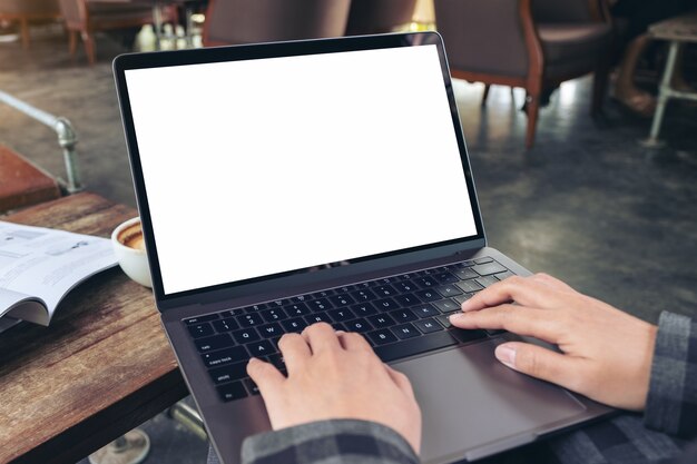 Mockup image of hands using and typing on laptop with blank white desktop screen