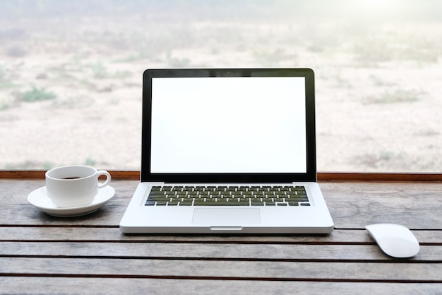 Mockup image of laptop with blank white screen on wooden table