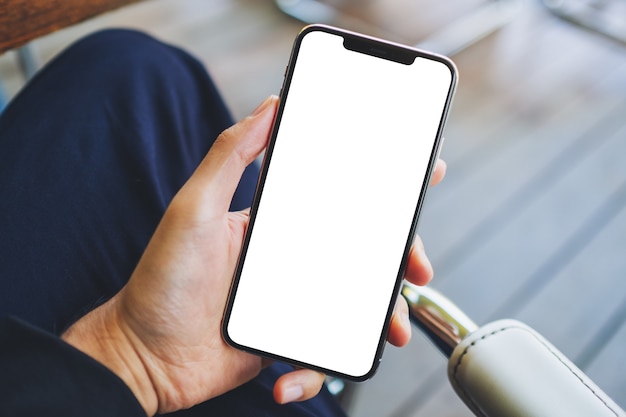 Mockup image of a man holding black mobile phone with blank white screen