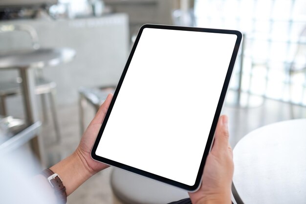 사진 빈 흰색 바탕 화면이 있는 디지털 태블릿을 들고 있는 여성의 모형 이미지