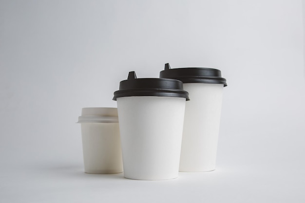 Mockup image of three paper cups with cap on clean bacground