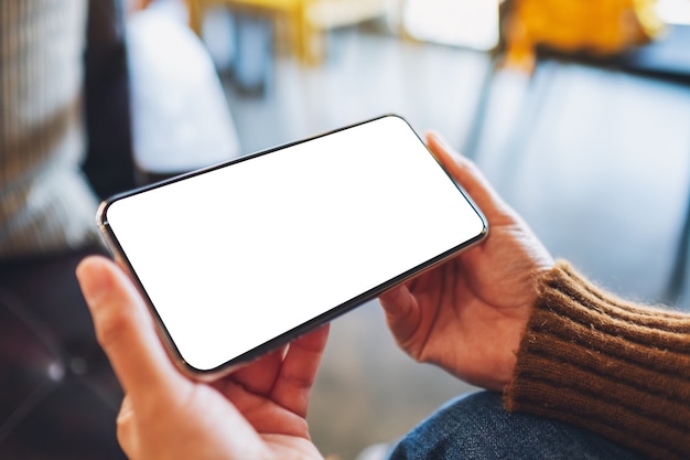 Mockup image of a woman holding black mobile phone with blank desktop screen