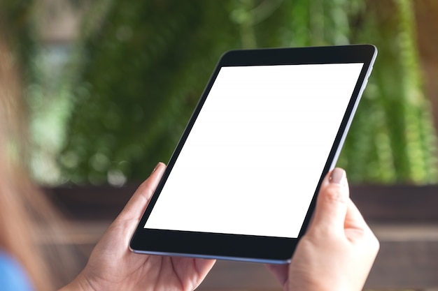 Mockup image of woman holding black tablet pc with white blank desktop screen