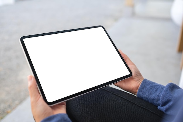 mockup image of a woman holding digital tablet with blank white desktop screen in the outdoors