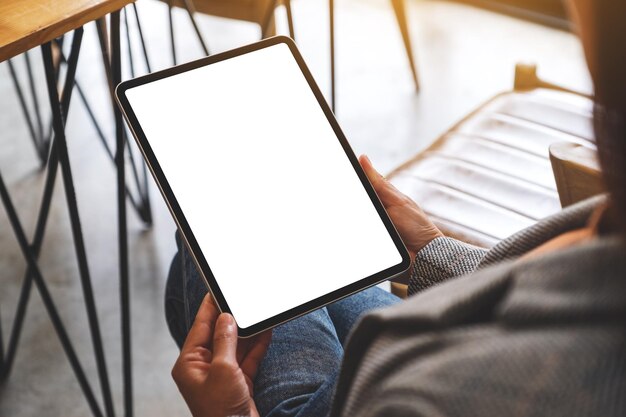 Mockup image of a woman holding digital tablet with blank white desktop screen