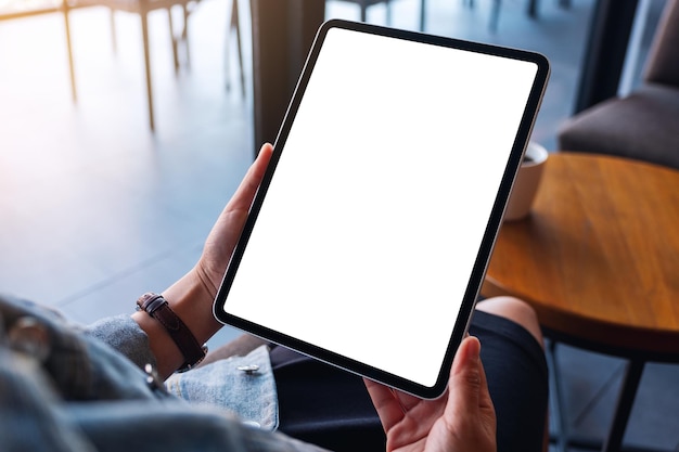 Mockup image of a woman holding digital tablet with blank white desktop screen