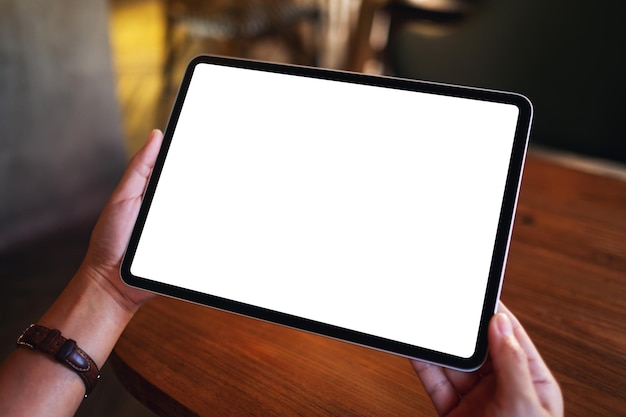 Mockup image of a woman holding digital tablet with blank white desktop screen