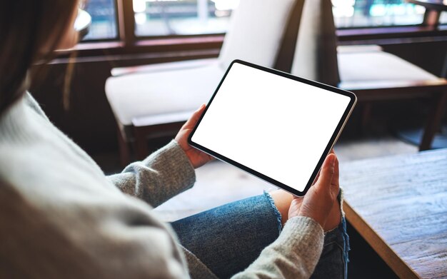 Mockup image of a woman holding digital tablet with blank white desktop screen