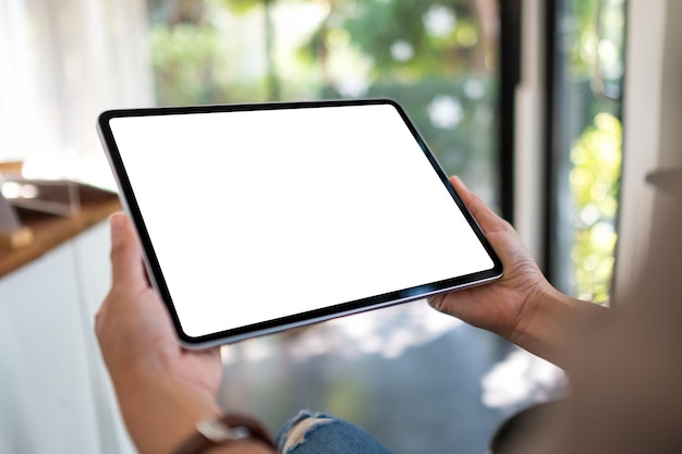 Mockup image of a woman holding digital tablet with blank white desktop screen