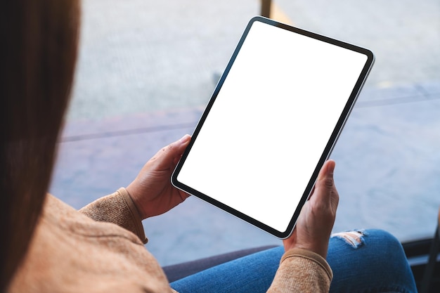 Mockup image of a woman holding digital tablet with blank white desktop screen