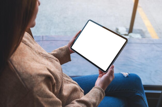 Mockup image of a woman holding digital tablet with blank white desktop screen