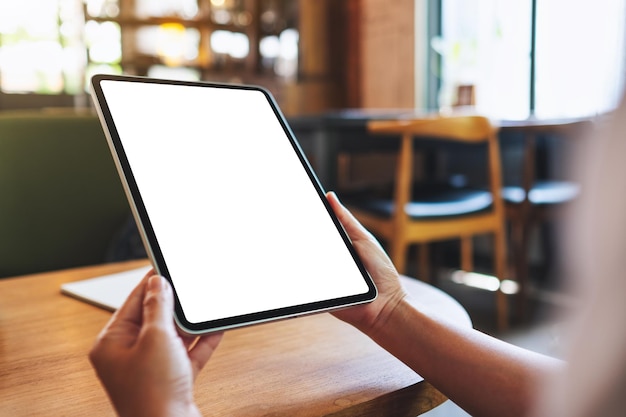 Mockup image of a woman holding digital tablet with blank white desktop screen