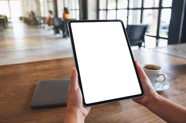 Mockup image of a woman holding digital tablet with blank white desktop screen