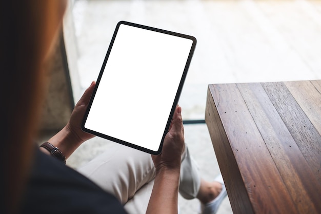 Mockup image of a woman holding digital tablet with blank white desktop screen