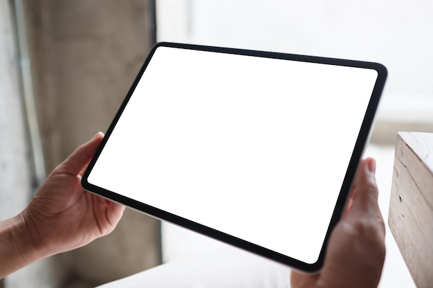 Immagine mockup di una donna in possesso di tablet digitale con schermo desktop bianco vuoto