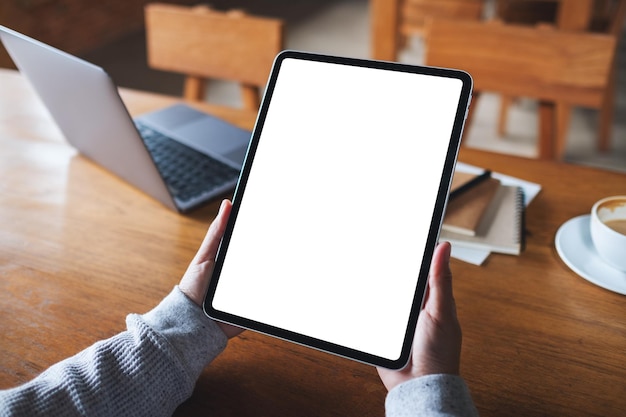 Mockup image of a woman holding digital tablet with blank white desktop screen