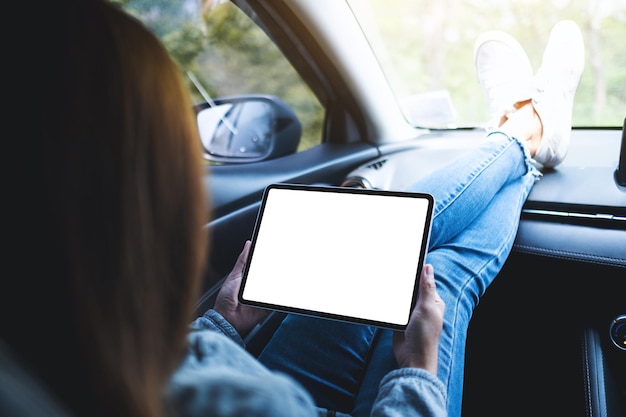 Mockup image of a woman holding and using digital tablet with blank screen in the car